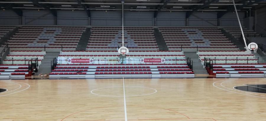 Sporthalle mit Teleskoptribüne und roten Sitzschalen